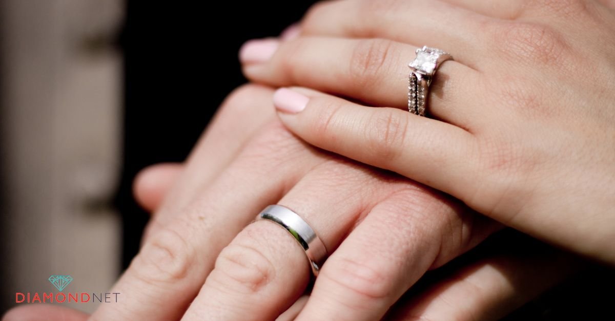 Close-up of a man and woman holding hands, showcasing their ring fingers