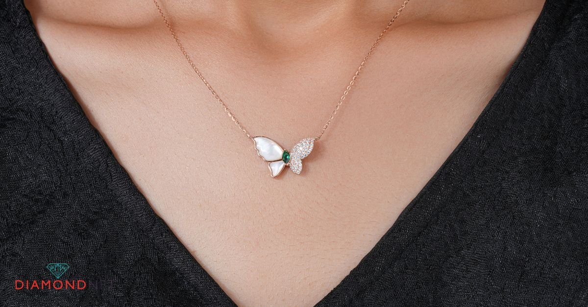 A woman showcases a gold butterfly necklace, representing butterfly jewelry meaning
