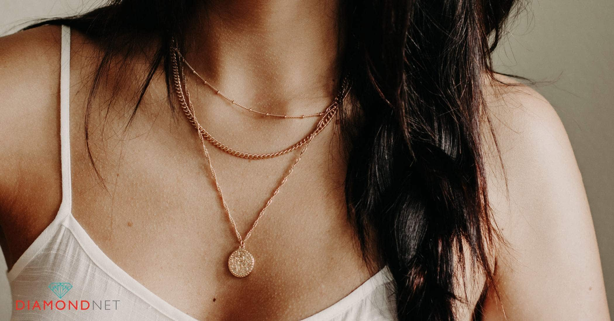 A woman elegantly displays her waterproof gold necklaces