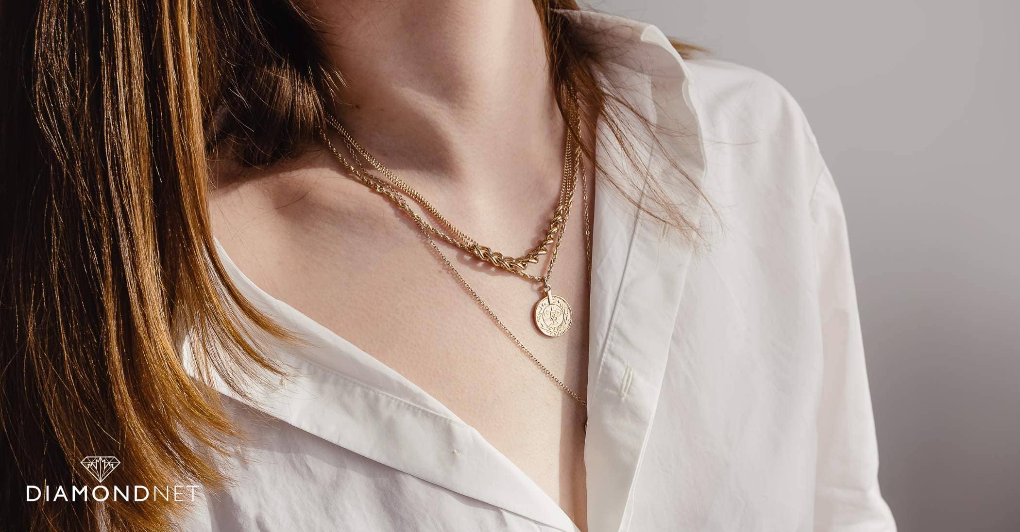 A woman displays layered necklaces, illustrating the art of layering different necklace styles