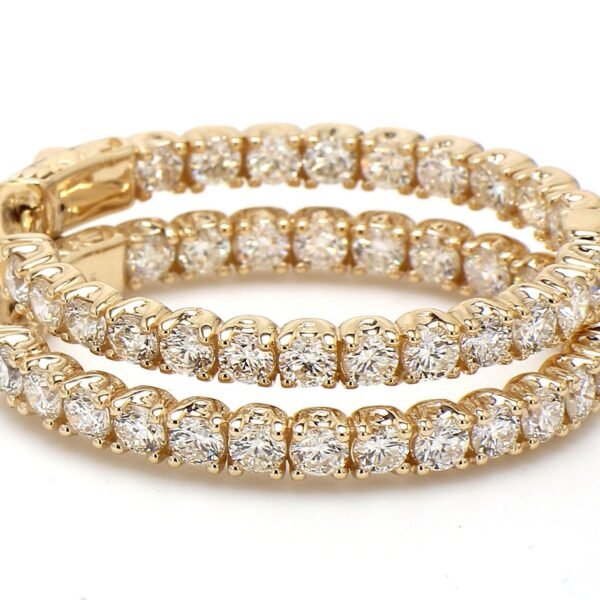 1.25' Oval shaped inside out hoop earrings in yellow gold with prong set round diamonds.  D4.77ct.t.w.