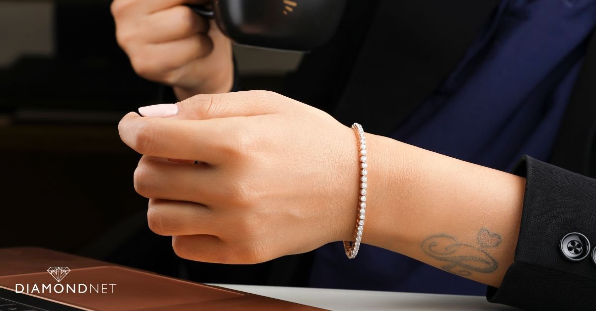 A woman showcases a stylish stack of bracelets, highlighting the latest trends in in tennis bracelets.