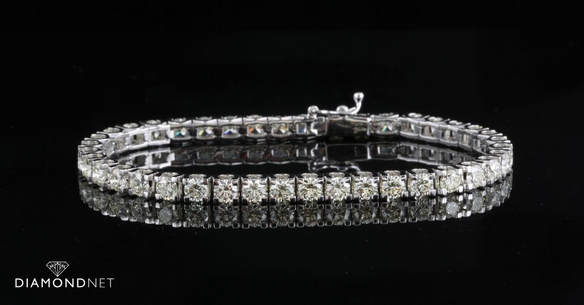 A woman showcasing a sparkling diamond tennis bracelet on her wrist, highlighting 2025 jewelry trends