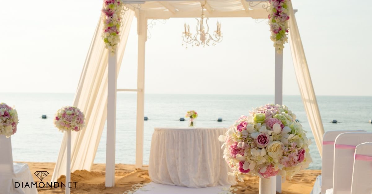 A beach wedding ceremony adorned with flowers, featuring personalized décor