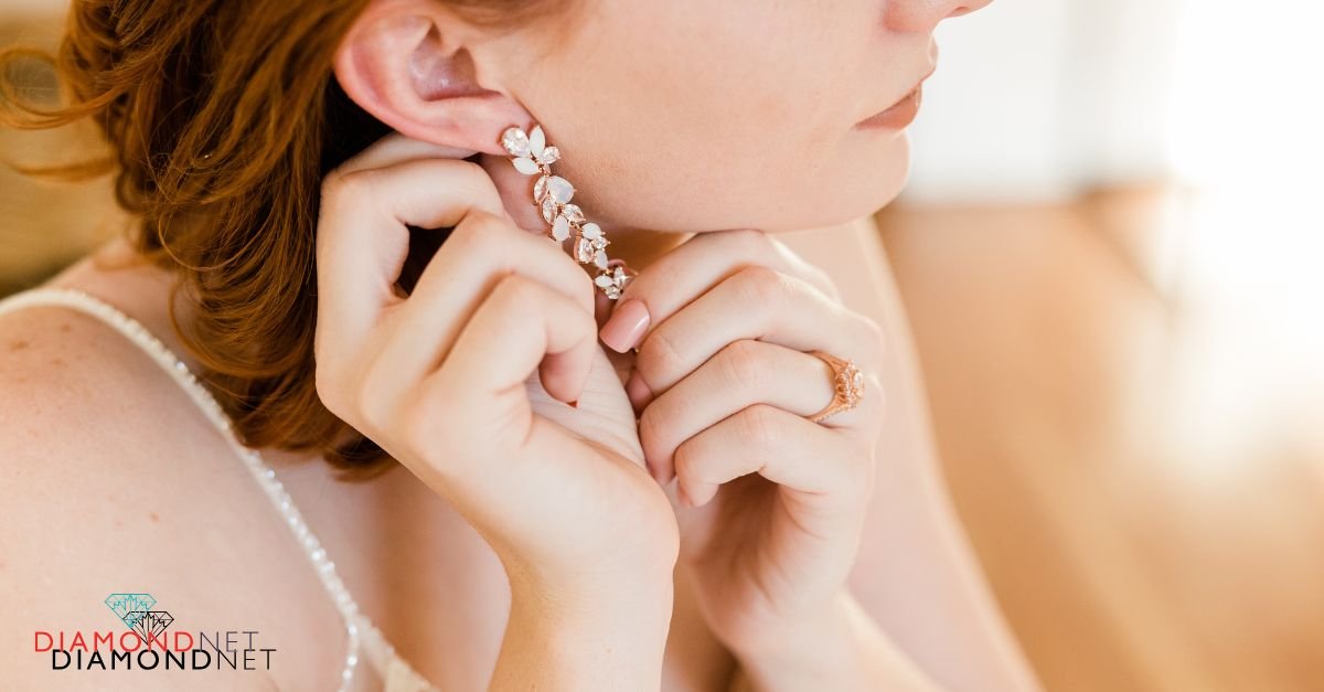 A woman in loose waves, wearing a white dress and bridal diamond earrings