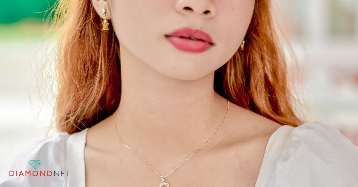A close-up of a woman's legs in a bubbly bathtub, featuring gold jewelry, showcasing the concept of showering with gold jewelry