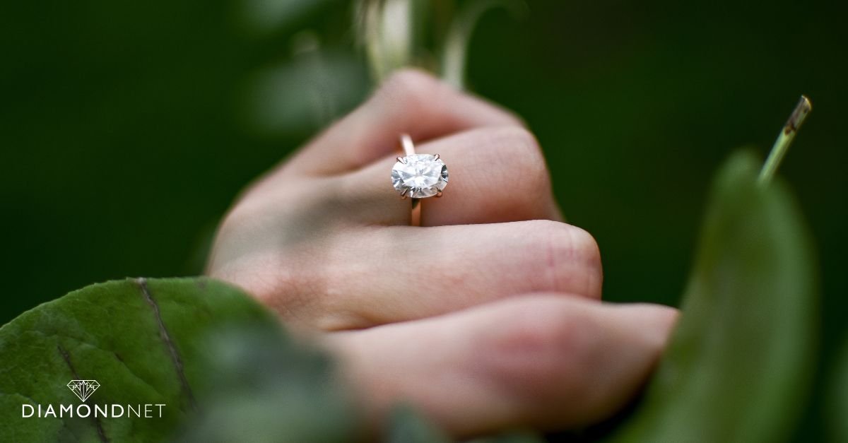 A person holding a diamond in their hand, demonstrating an at-home diamond testing method